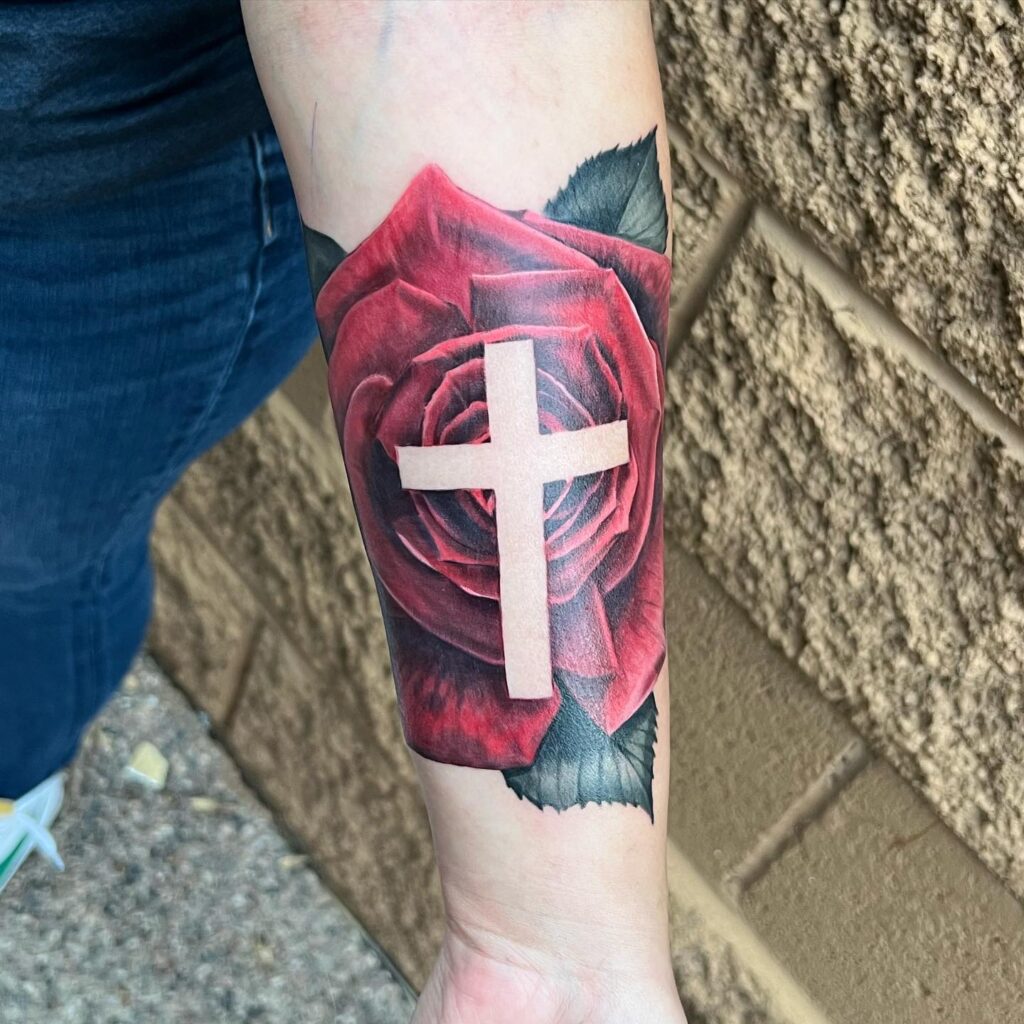 Inner forearm colorful red rose with cross tattoo a vibrant display of faith