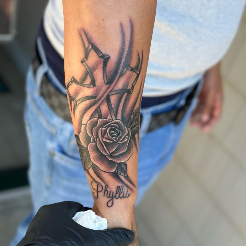 Inner forearm cross with rose tattoo for men symbolic ink
