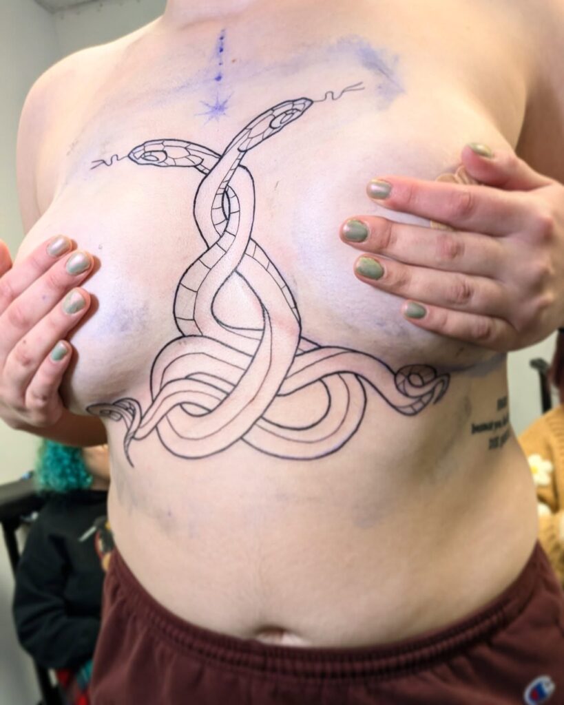 Intertwined snakes sternum tattoo with bold symmetrical placement