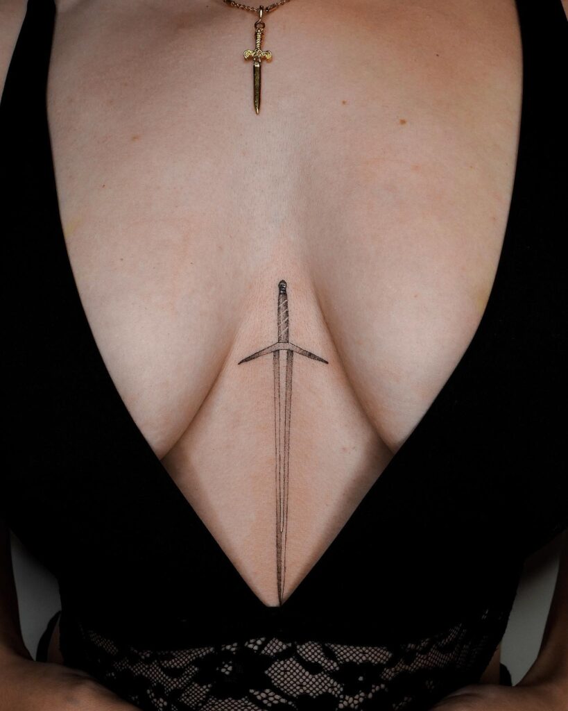 Intricate fine-line sword sternum tattoo representing strength and protection