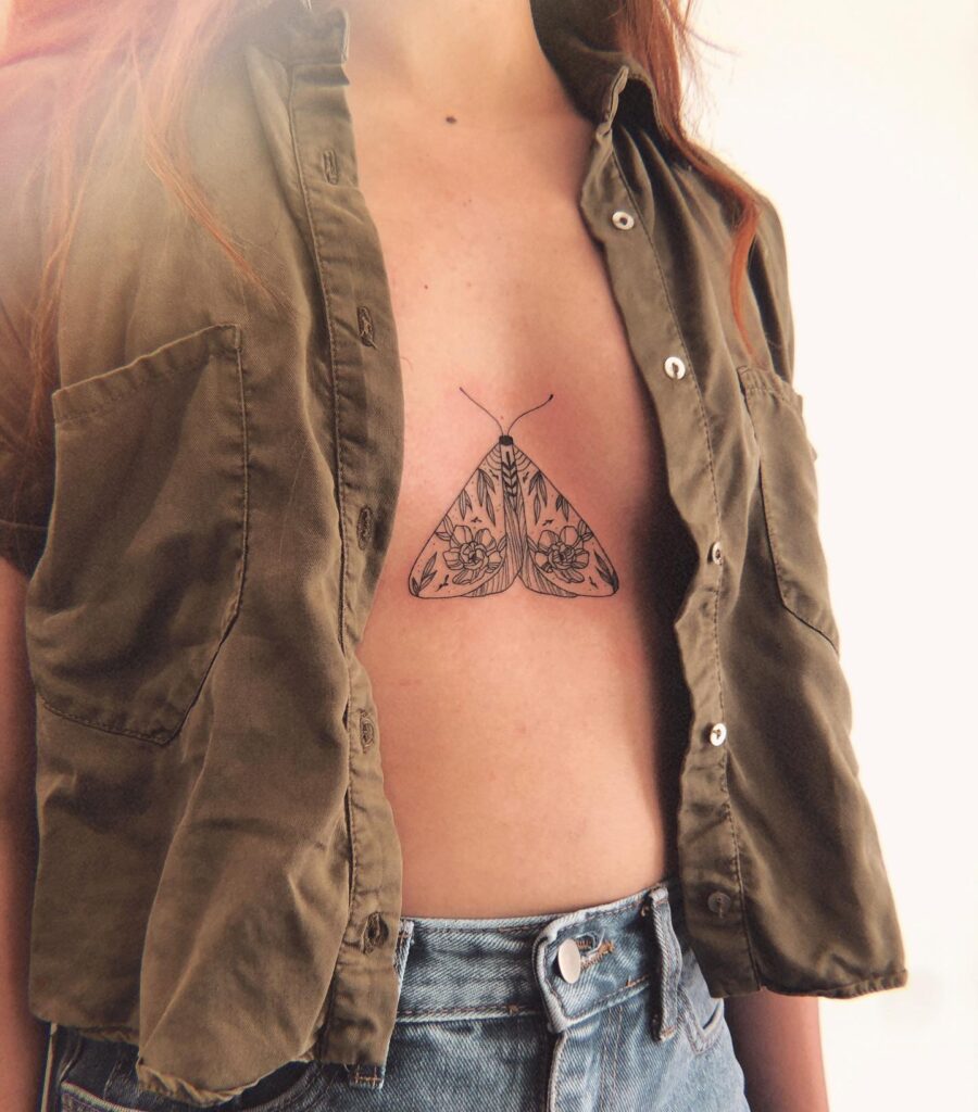 Intricate floral moth sternum tattoo symbolizing transformation and resilience