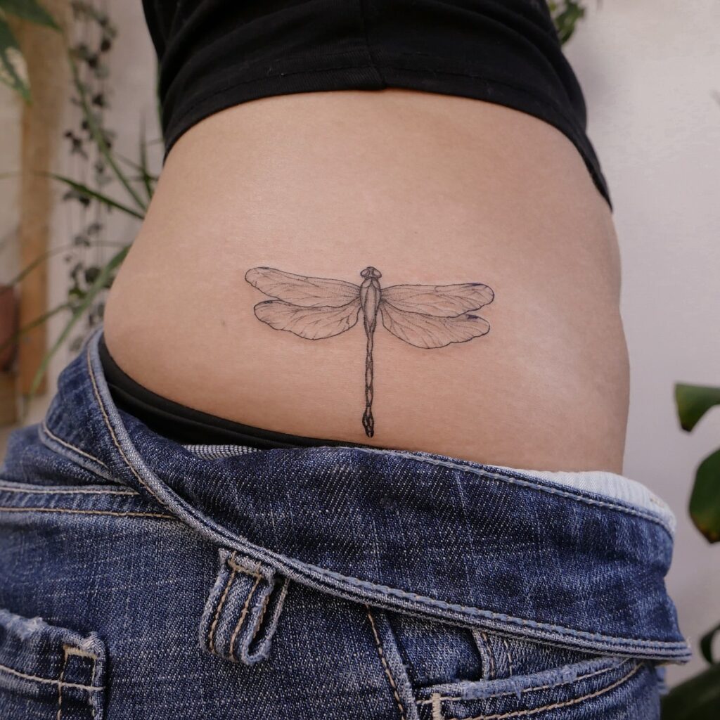 Intricate Lower Back Dragonfly Tattoo with Delicate Shading