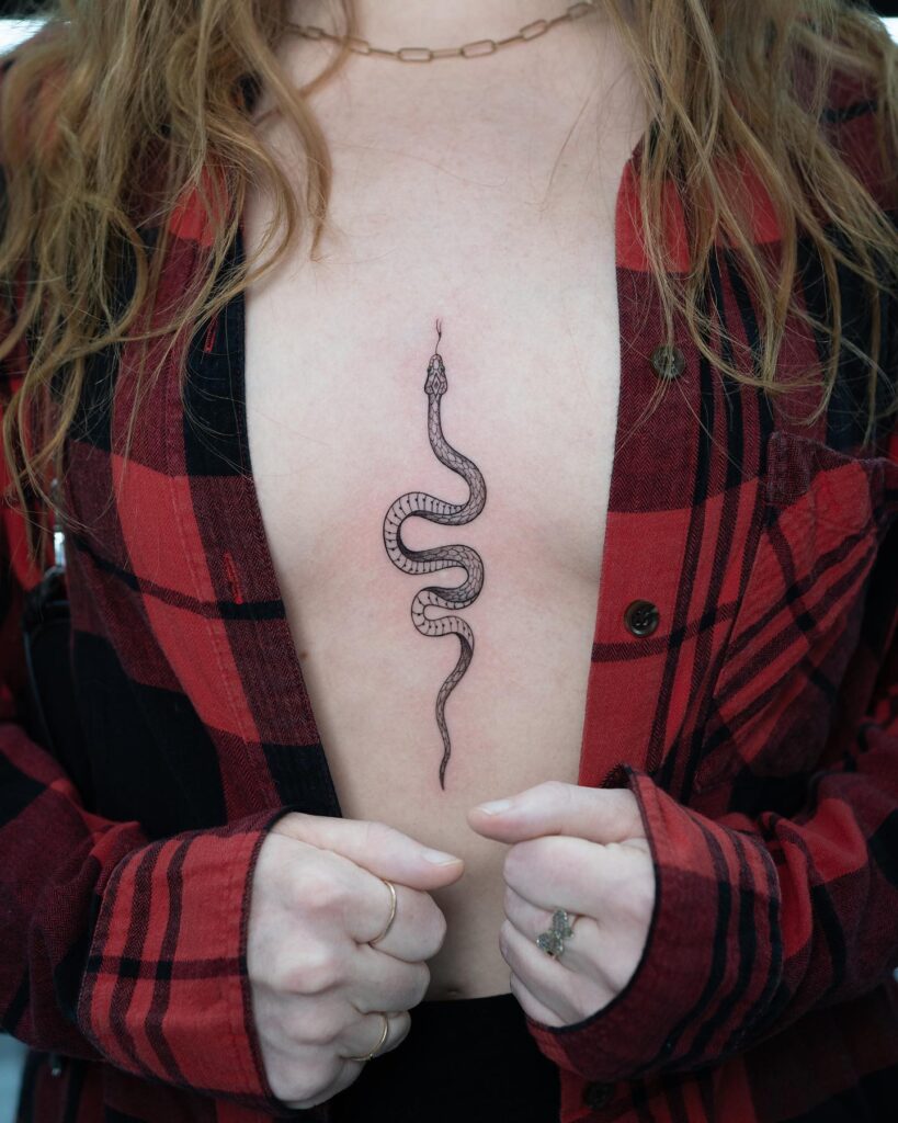 Intricate snake sternum tattoo symbolizing transformation and strength