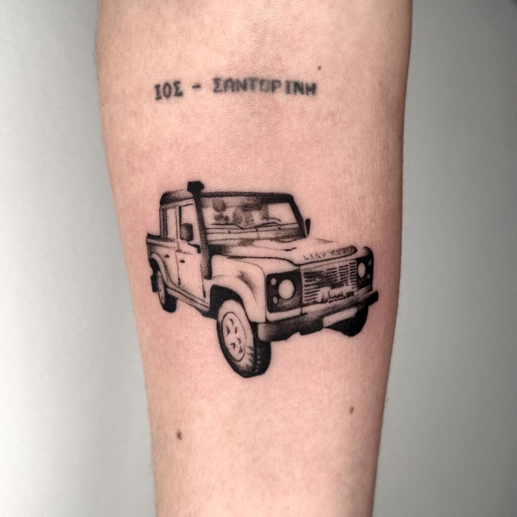 Land Rover Defender Tattoo with "IOS - SANTERINI" Text on Forearm – Adventure Car Tattoo Ideas