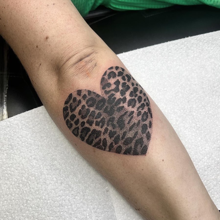 Leopard print tattoo on outer forearm below the elbow heart filled with leopard print
