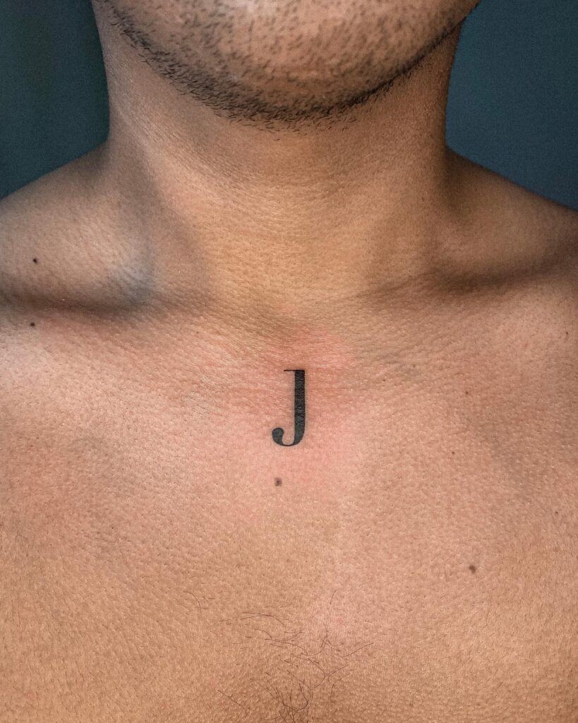 Letter 'J' Tattoo at the Center of the Chest: Bold Centerpiece