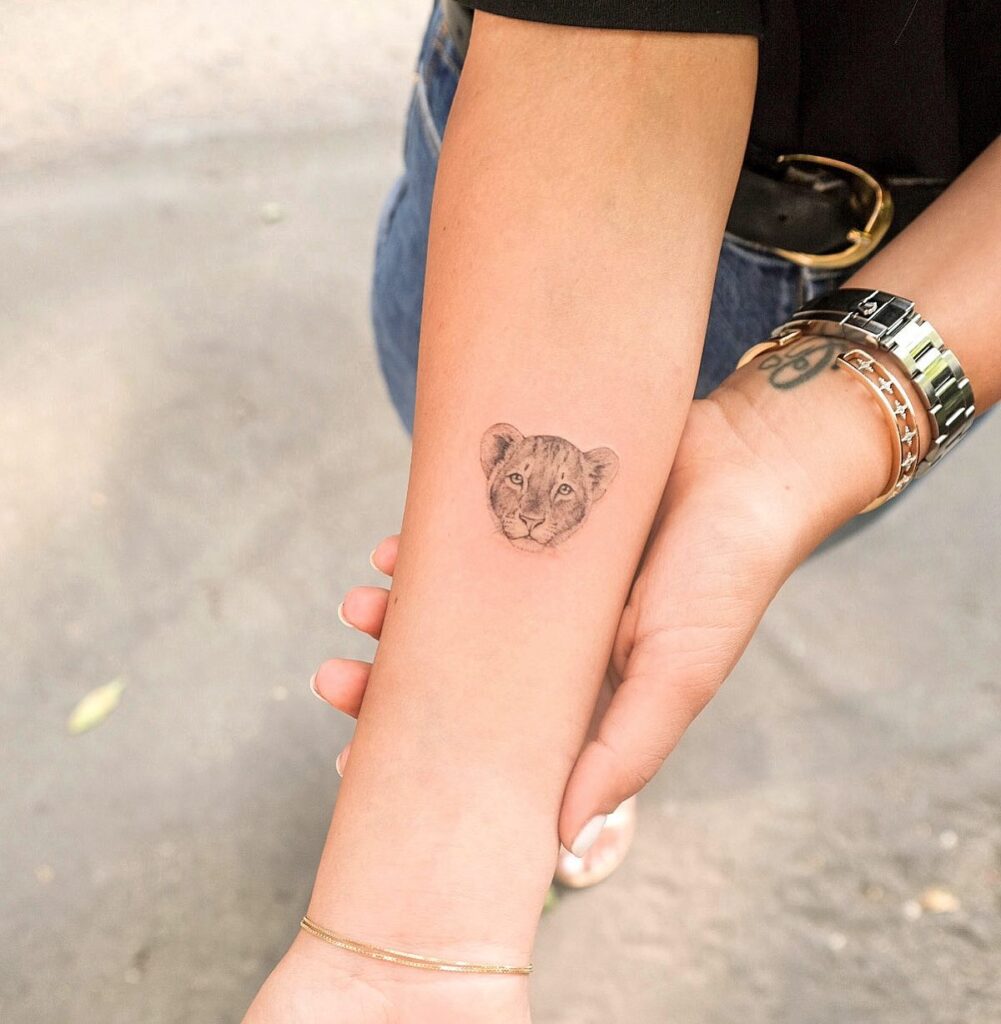 Lion cub love small shaded baby lion tattoo on the inner forearm