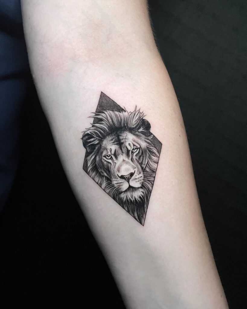 Lion face inside diamond shape black work tattoo on the forearm: diamond majesty