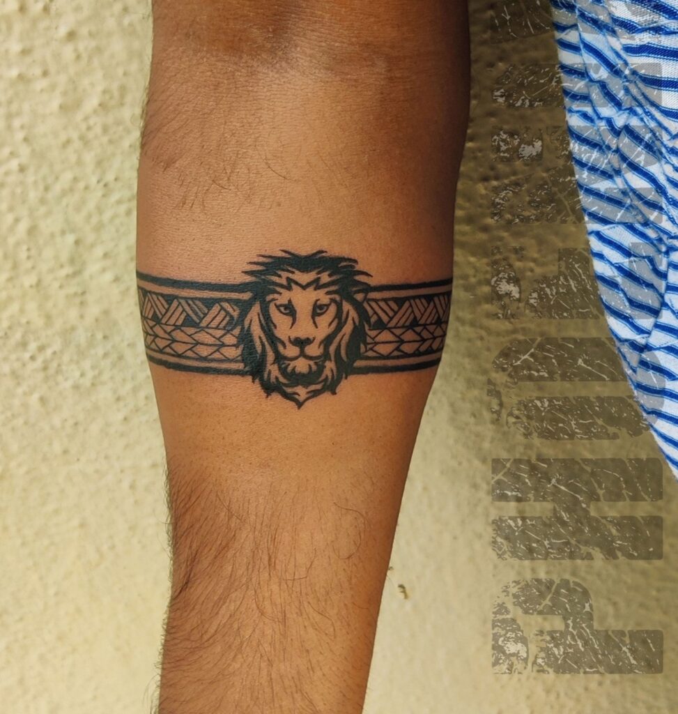 Lion head tattoo with black work tattoo for a bold arm band: lion arm band