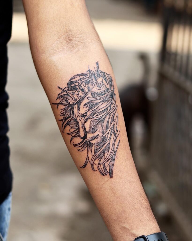 Lion side face with crown tattoo on the forearm: stylish geometric mane