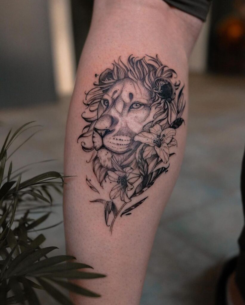 Lion side view face tattoo with floral accents on the calf for men: graphic charm