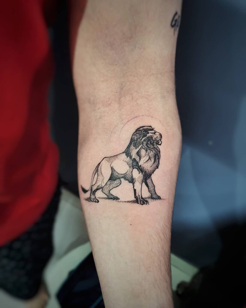 Lion side view full body tattoo below the elbow: fearless roar