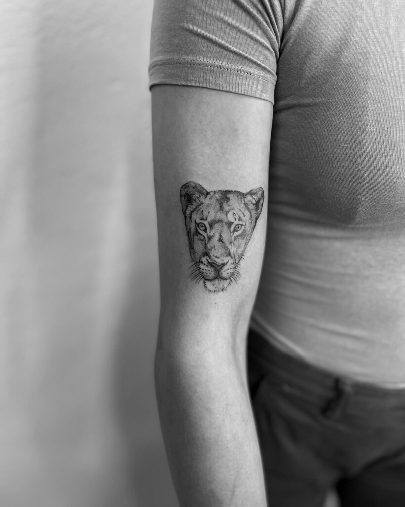 Lioness face tattoo on the arm for a powerful statement: fierce lioness