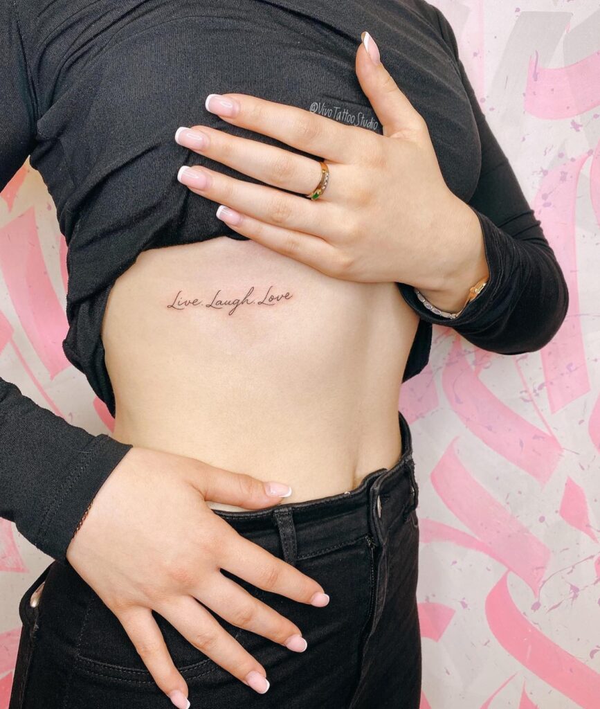 Live laugh love as small lettering underboob tattoo