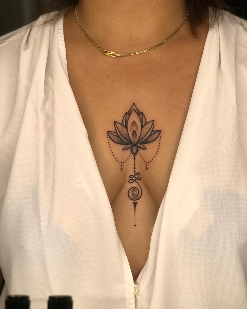 Lotus flower sternum tattoo with delicate swirls and dotwork for balance