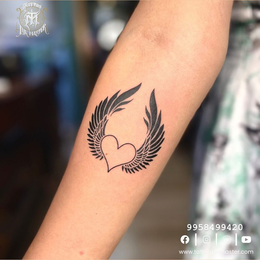 Love and freedom forearm tattoo with heart and wings