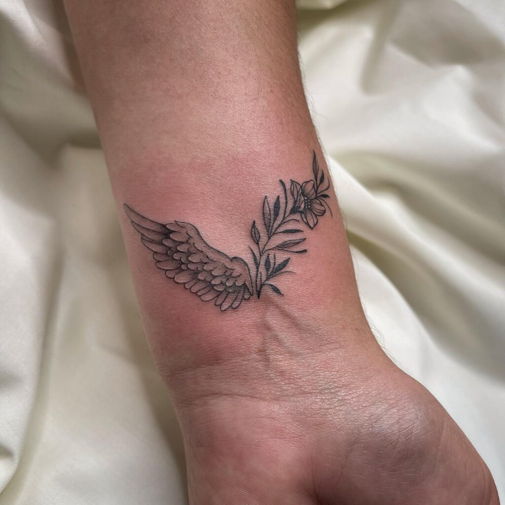 Lovely Flowered Wings Tattoo on the Wrist, a Fusion of Nature's Elegance: Blooming Flight