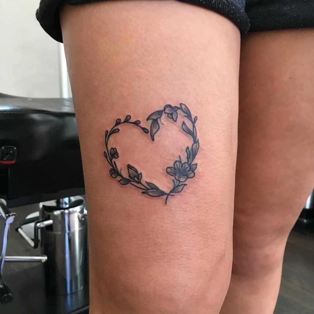 Lovely little love heart composed of flowers above the knee tattoo