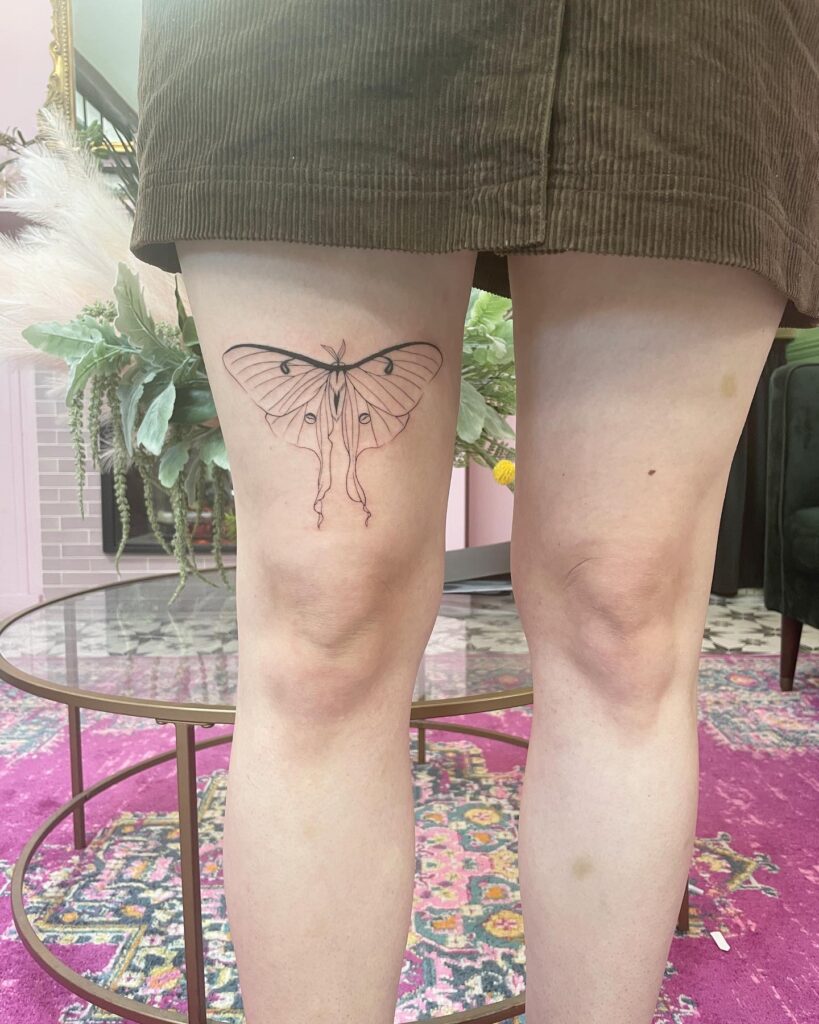 Luna moth elegance fine line thigh tattoo above the knee