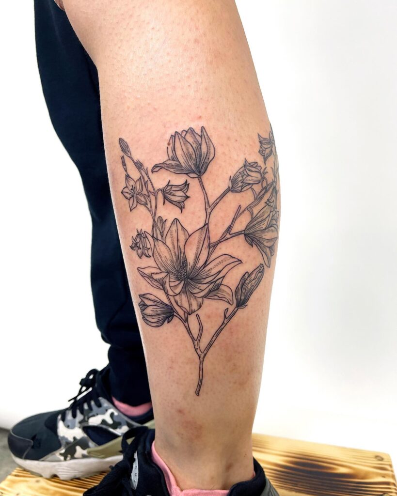 Magnolia and bluebell flowers calf tattoo botanical elegance