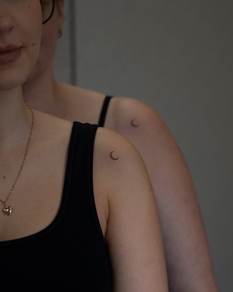 Matching crescent moon tattoo on shoulder for family bond