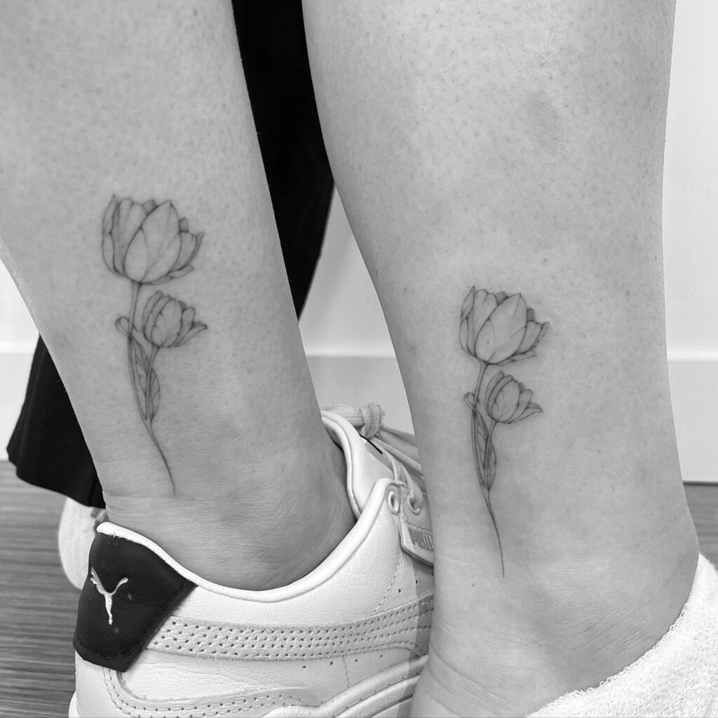 Matching tulip ankle tattoos symbolizing love and nurturing between mother and daughter