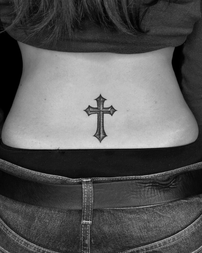 Meaningful back ink cross tattoo for women's lower back