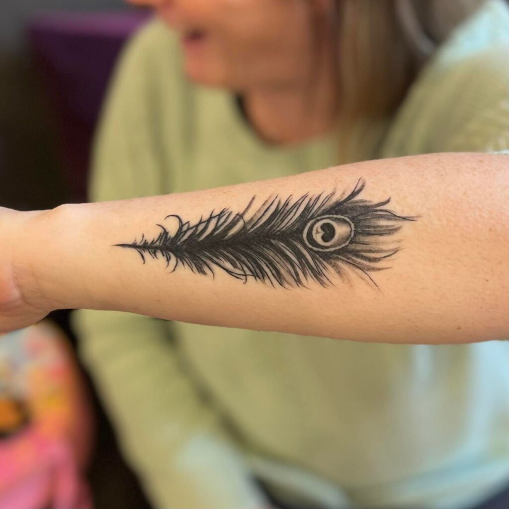 Meaningful Side Peacock Feather Black Color Wrist Tattoo Design : Significance in Ink