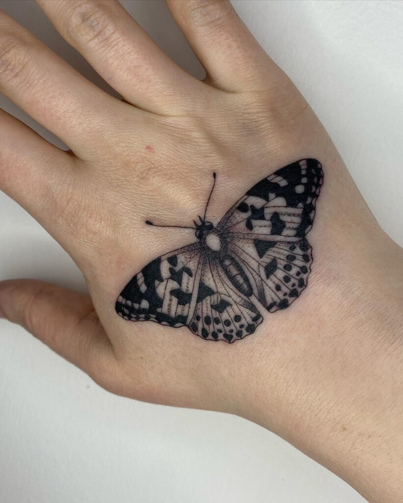 Medium-sized butterfly tattoo on the hand a graceful accent