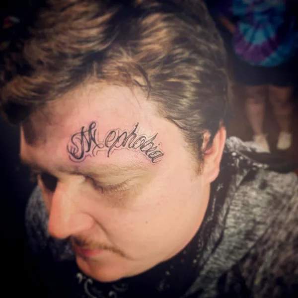 Mephobia forehead tattoo