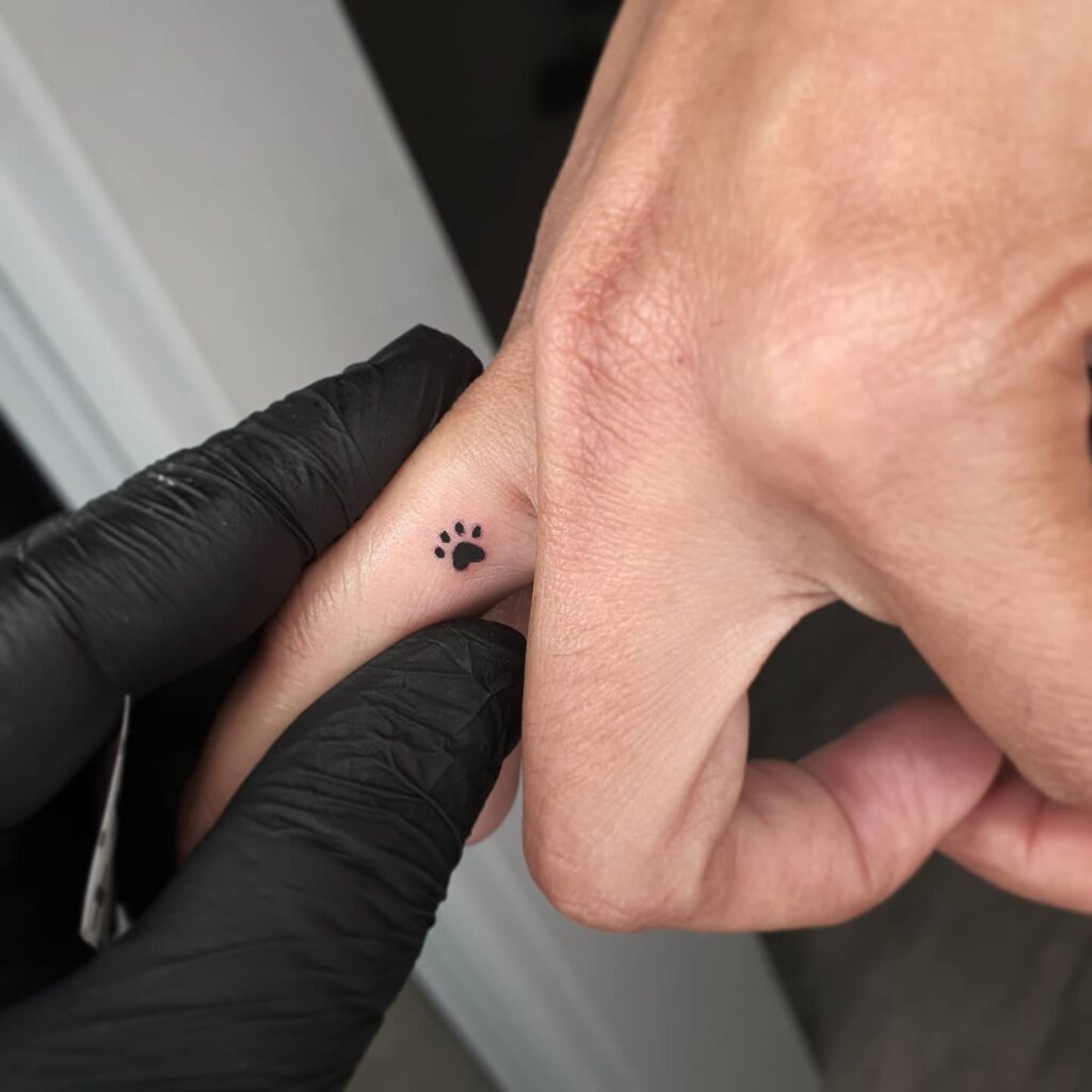Micro Paw Tattoo on the Side of the Middle Finger: Finger Whispers