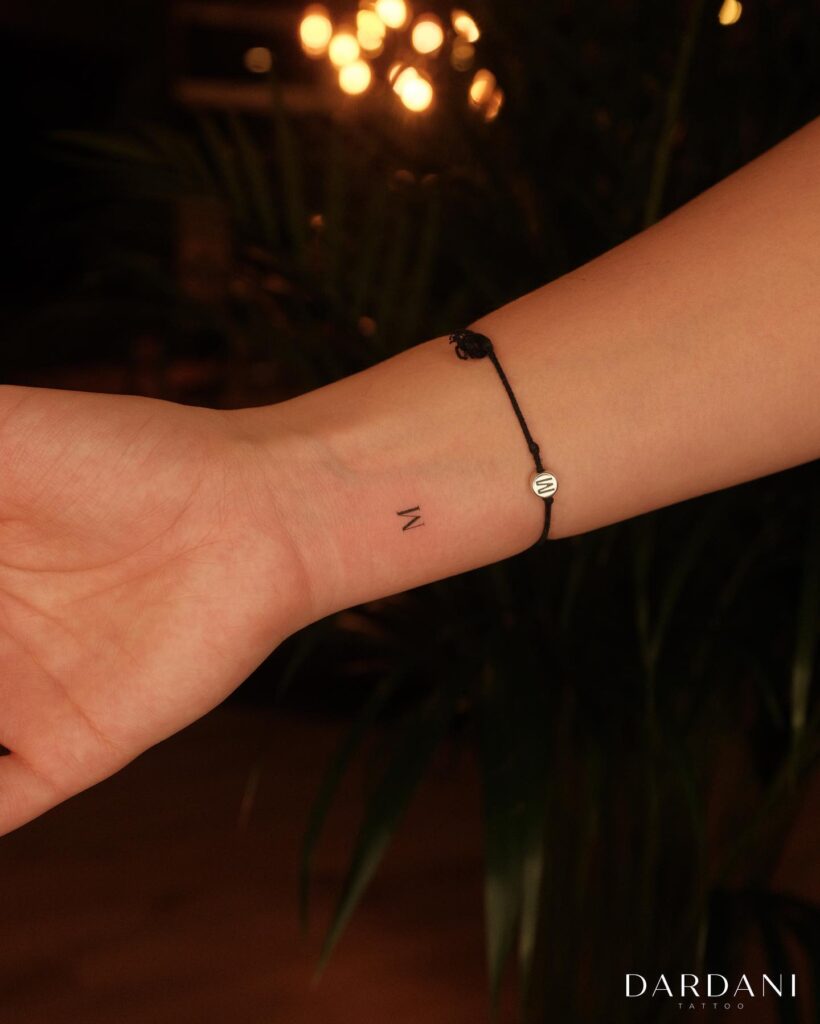 Mini 'M' Letter Tattoo on the Inner Wrist: Inner Elegance