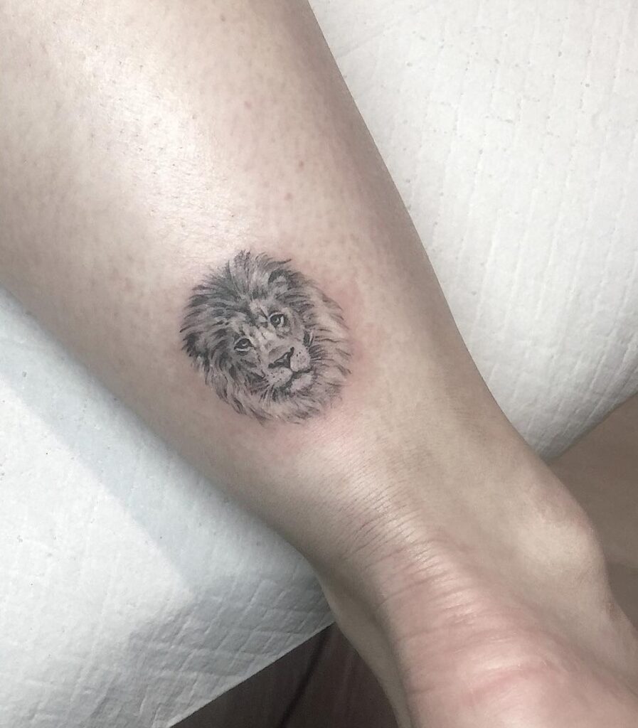 Mini lion face grey shaded tattoo on the back of the ankle for females: ankle elegance
