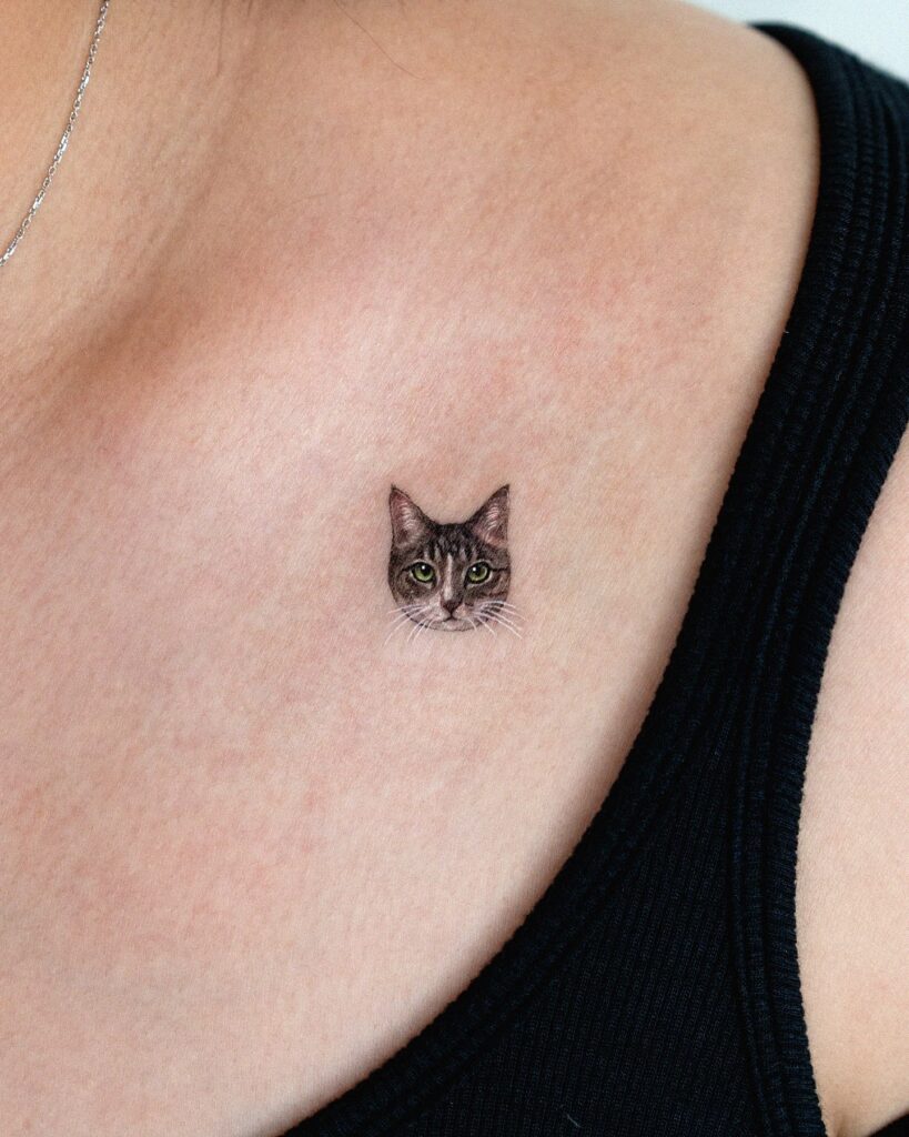 Mini realistic tabby cat face tattoo near collarbone