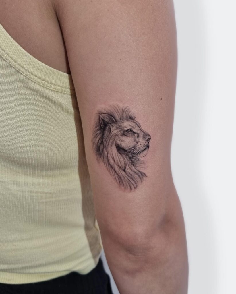 Mini side view lion face grey shaded tattoo on the back of the arm: above the elbow majesty