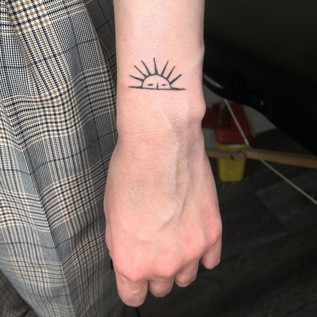 Miniature sun tattoo on outer wrist a sneaky sunshine