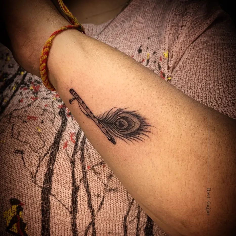 Minimal Flute Tattoo with Peacock Feather on Hand Harmonious Combination