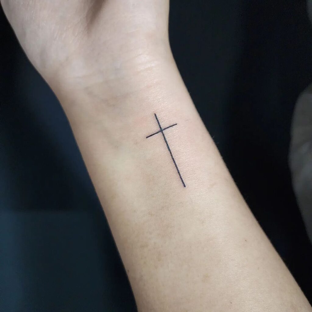 Minimal cross ink on inner wrist embrace simplicity with thin line cross tattoos