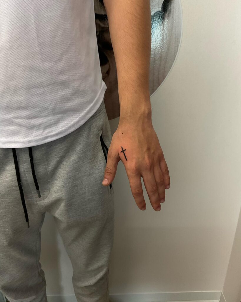 Minimalist Forearm Tattoo Small Cross Design Near the Thumb for Men