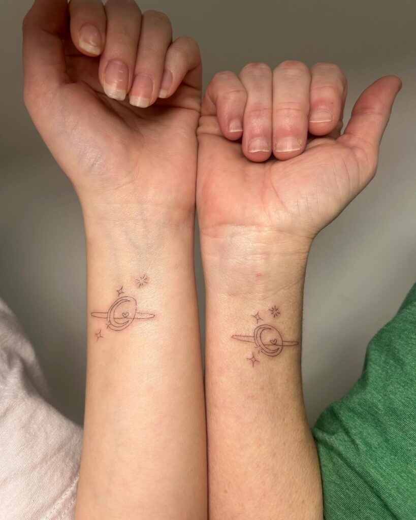 Minimalist Saturn planet wrist tattoo for mother and daughter bond