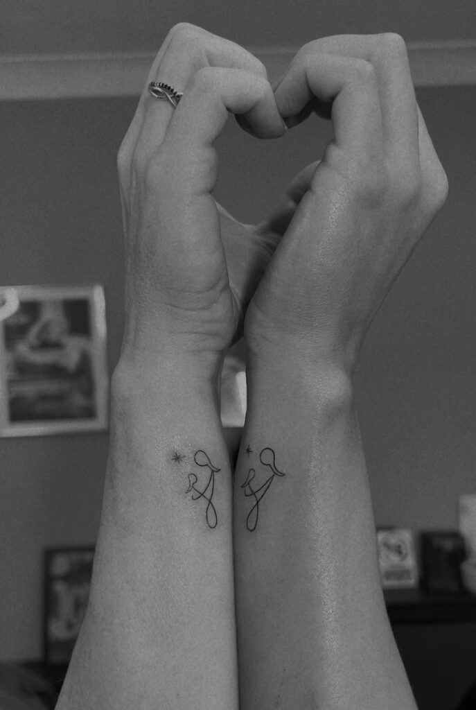 Minimalist Continuous-Line Mother Daughter Tattoos with Hand-Holding Design