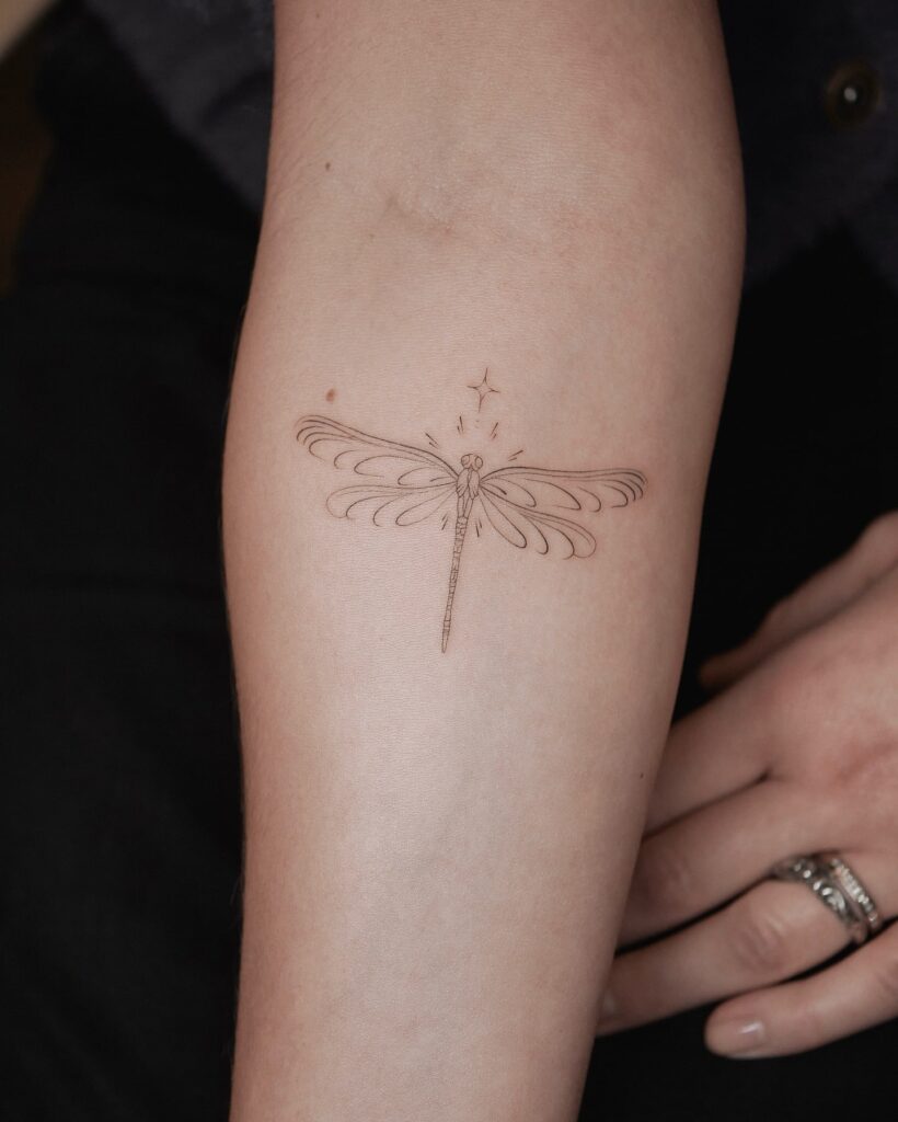 Minimalist Dragonfly Tattoo with Star Accents and Intricate Wings