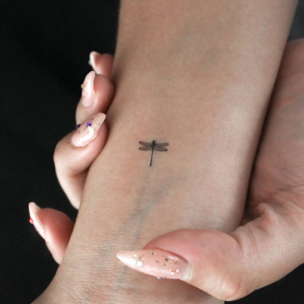 Minimalist Dragonfly Wrist Tattoo with Elegant Fine-Line Detailing