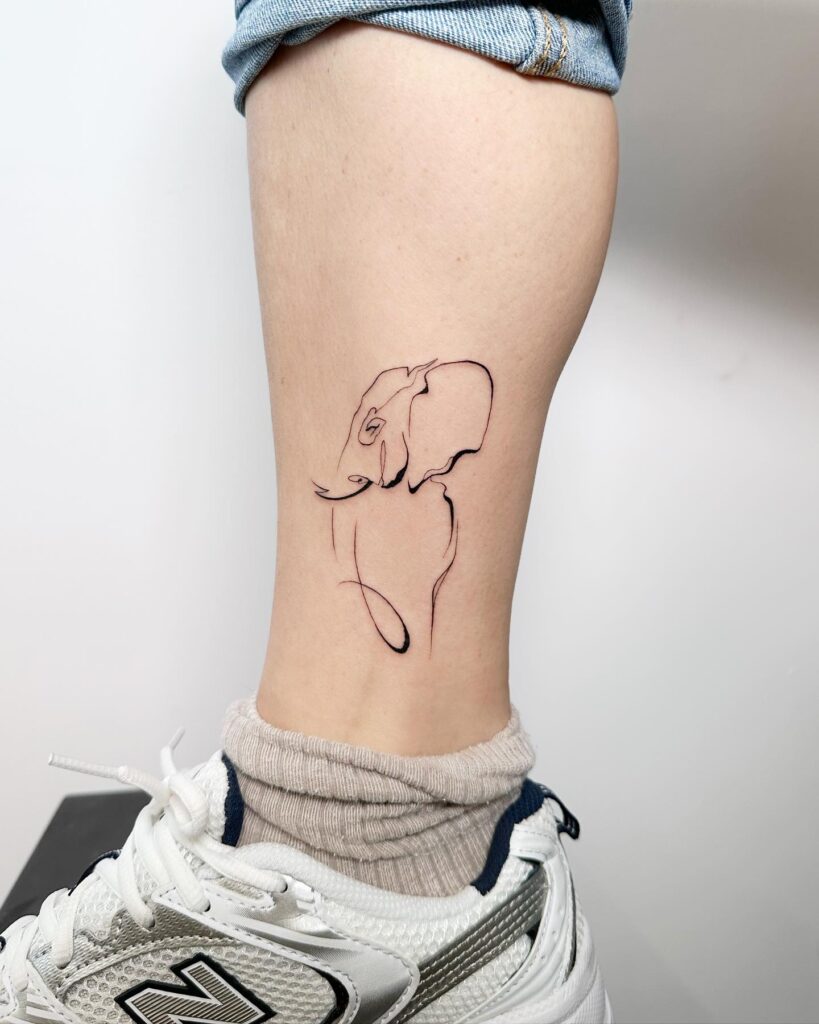 Minimalist elephant head tattoo above the ankle: abstract elegance in ink