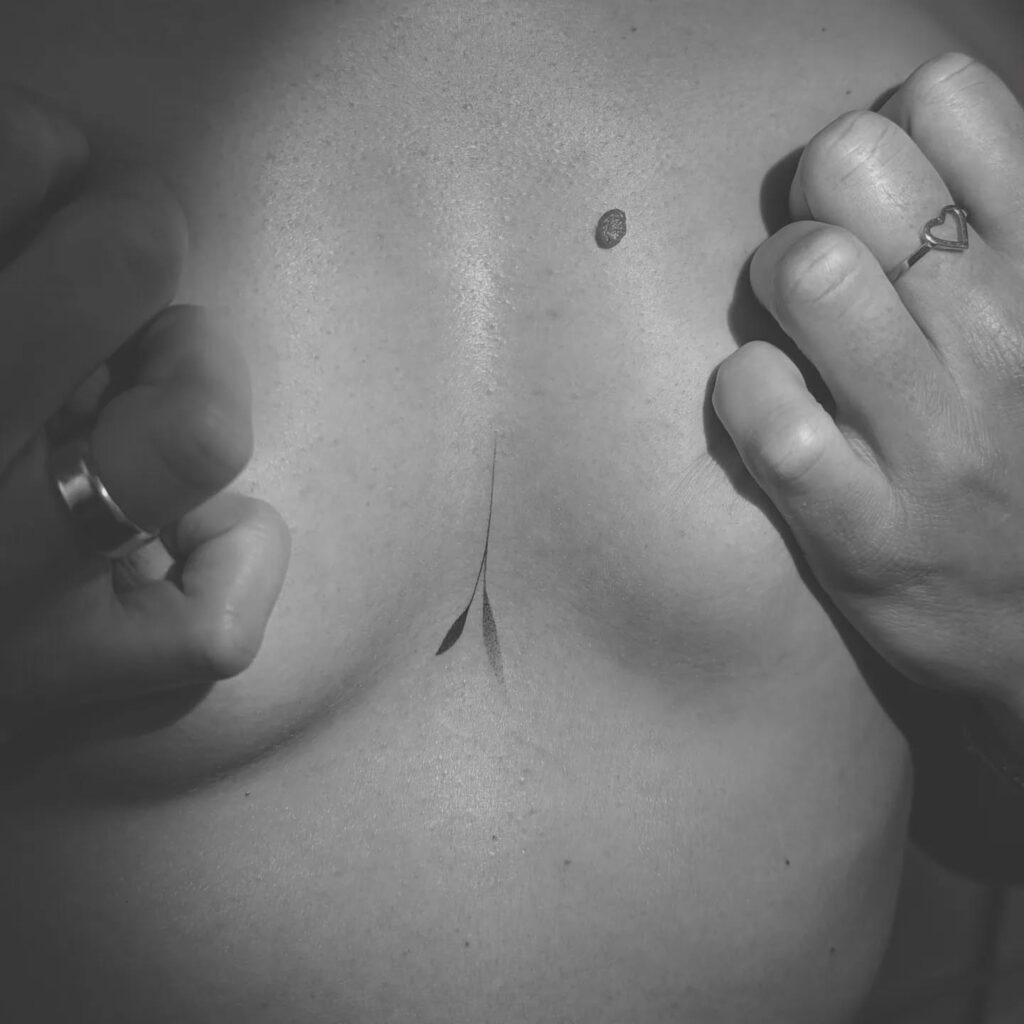 Minimalist fine-line leaf sternum tattoo symbolizing growth and balance