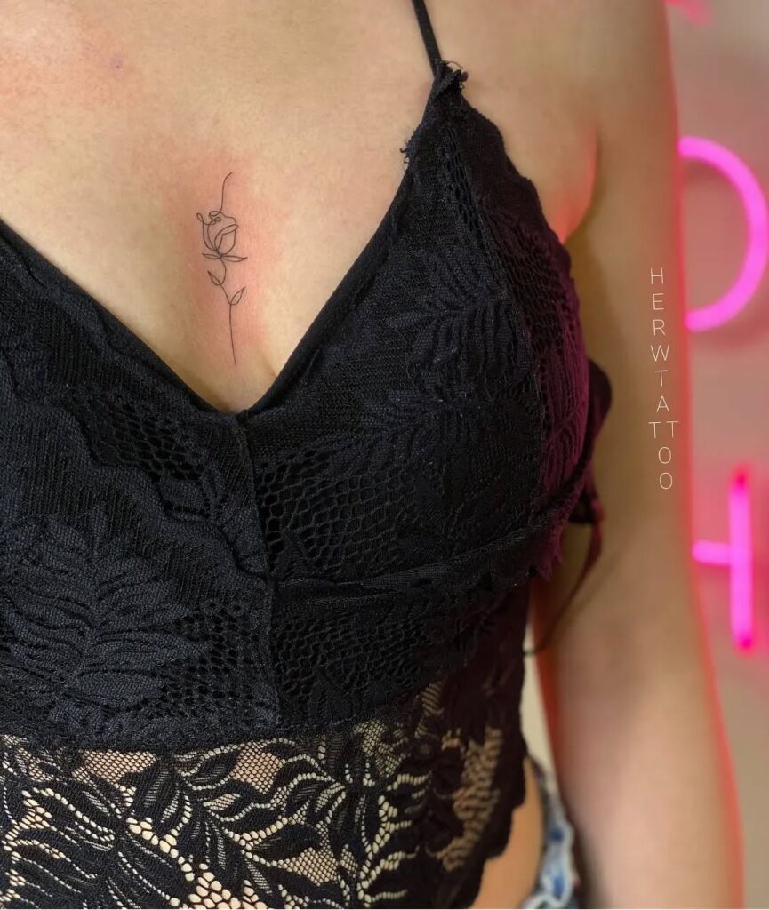 Minimalist fine-line rose sternum tattoo with elegant simplicity
