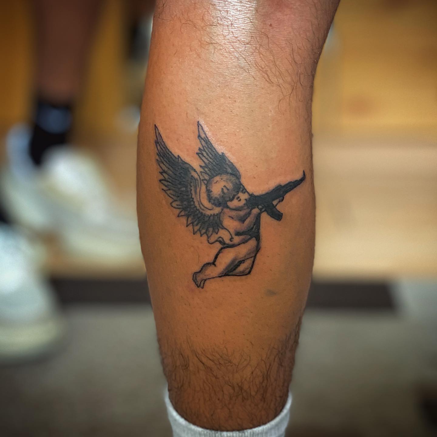 Minimalist flying angel with gun tattoo for male and female Minimalist flying angel with gun tattoo for male and female