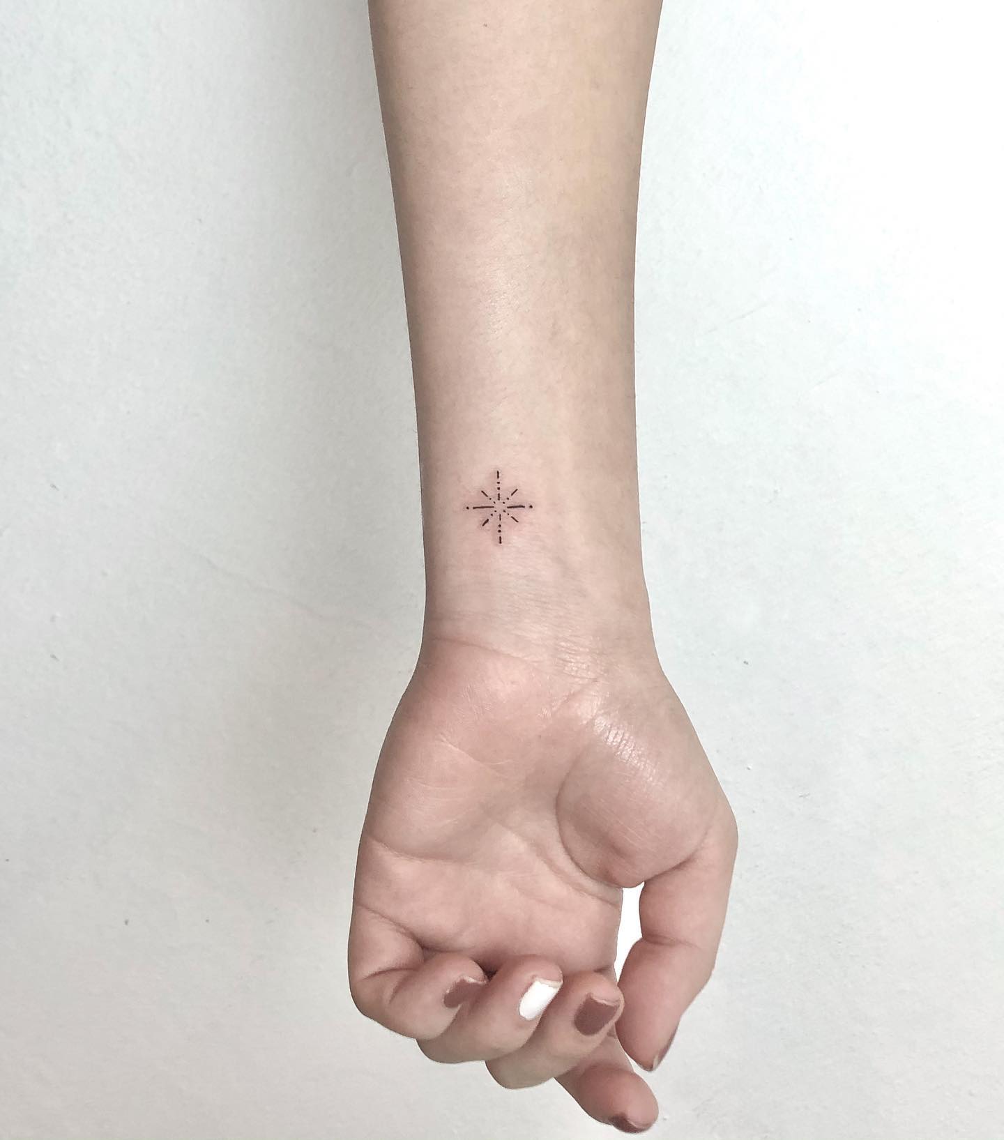 Minimalist Geometric Star or Compass Wrist Tattoo Elegant and Subtle