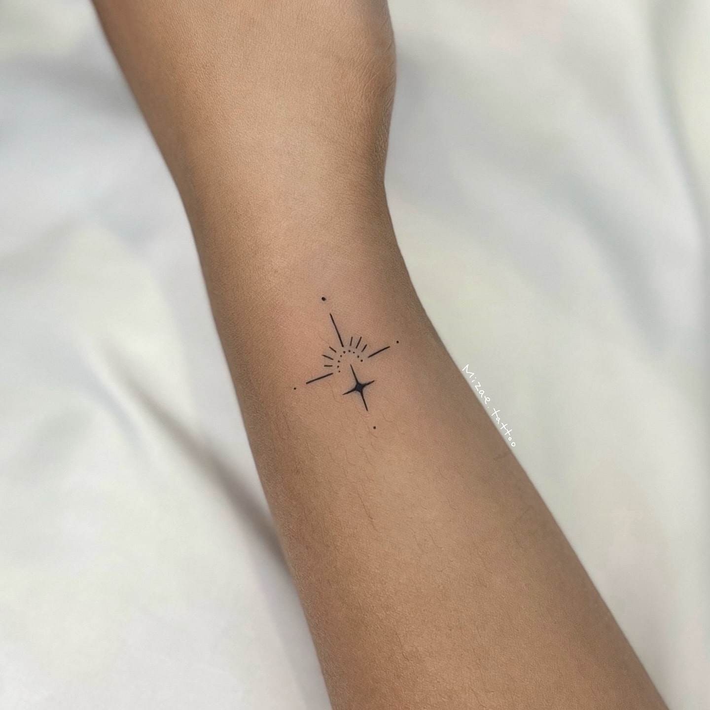 Minimalist geometric starburst tattoo symbolizing light guidance