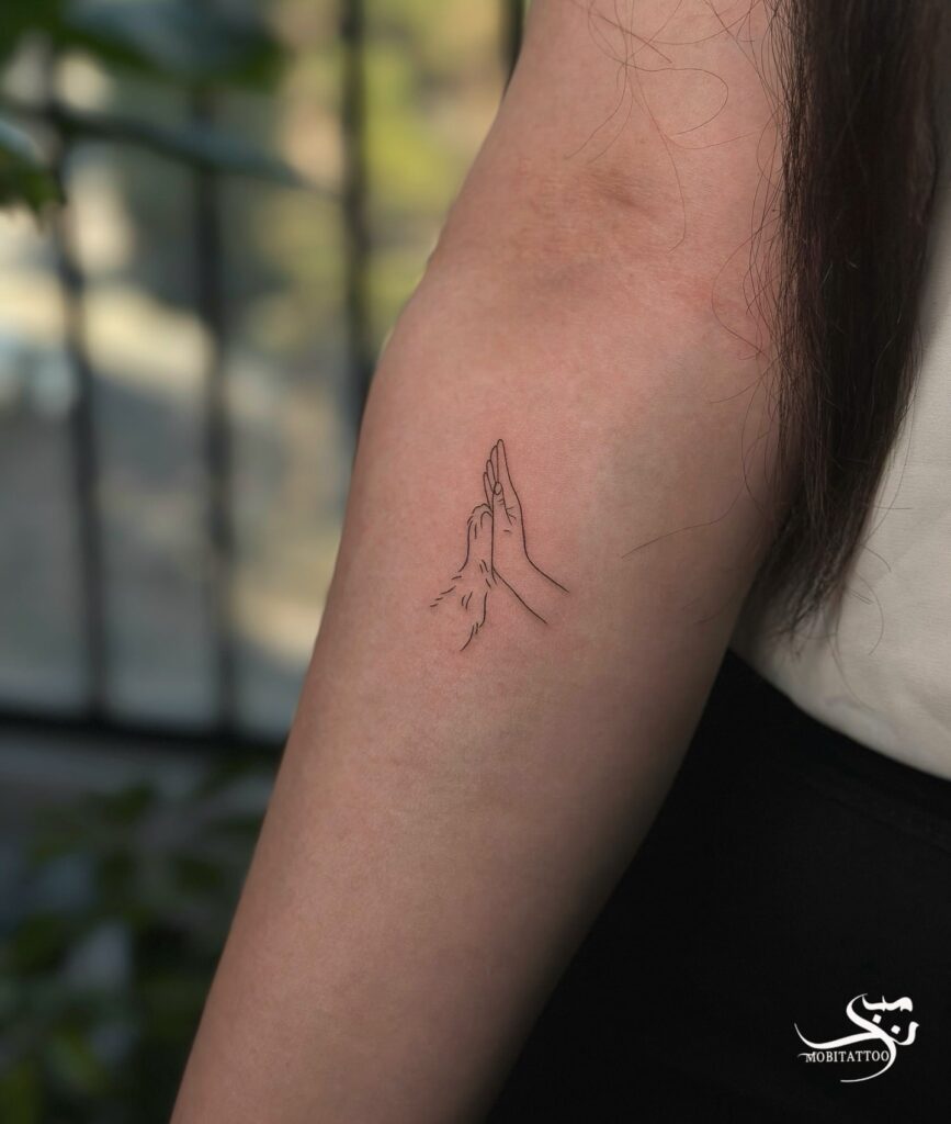 Minimalist Hand and Paw Tattoo on the Forearm: Paw Prints and Harmony